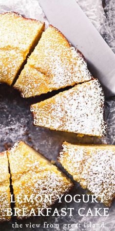 a cake with powdered sugar on top sitting next to a knife