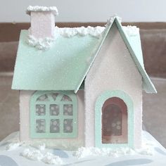 a small doll house with snow on the roof