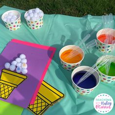 ice cream cones, cups and markers on a blue sheet with green grass in the background