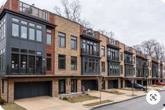 a row of brick townhouses with garages on each floor and balconies on the second story