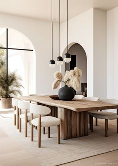 a dining room table with chairs and a vase on it