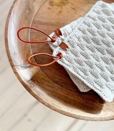 a white knitted bag sitting on top of a wooden table