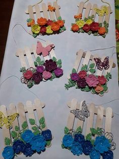 several pieces of paper with flowers and butterflies on them sitting on a white table cloth