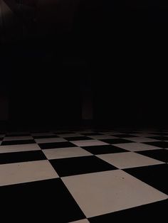 a black and white checkered floor in a dark room