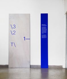 two tall blue and white columns in an empty room with numbers on the wall next to them