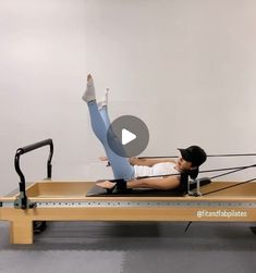 a woman is doing pivots on a rowing machine with the help of an instructor