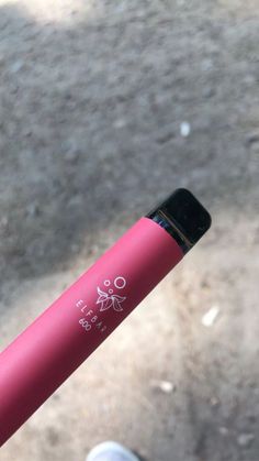 a close up of a pink bike handlebar with writing on the side and an image of a person's foot in the background