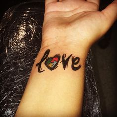 a person's wrist with the word love tattooed on it and a heart in the middle