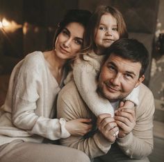 a man, woman and child sitting on a couch