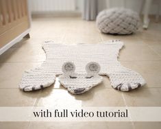 a crocheted cat rug on the floor with text overlay that reads, with full video tutorial