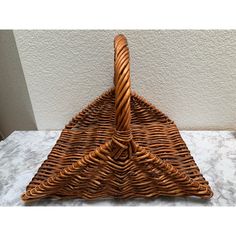 a brown wicker basket sitting on top of a table next to a white wall