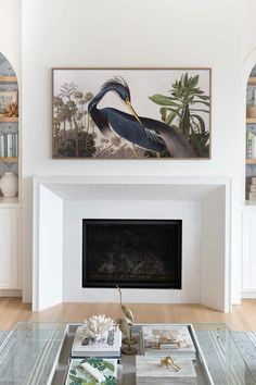 a living room filled with furniture and a painting on the wall above a fire place