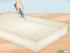 a person using a pair of scissors to cut a piece of paper on a table