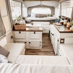 the interior of a camper with white cabinets and wood flooring is shown in this image