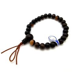 Black Kaki Wood Japanese Juzu Bracelet Material : Black Kaki (Persimmon) Wood, Silk elastic cord Size: about 17cm (Stretch) We adjust the size to your wrist for fee. Head bead : about 12mm / 15mm Main beads : about 8mm / 13mm Handmade in Kyoto, JAPAN The Japanese persimmon has a very beautiful wood grain. The charm of this wood with a rare and mysterious pattern seems to have particularly influenced people of the Japanese emperor and emperor's aides, nobles, writers, poets, calligraphers, tears Traditional Black Bracelet With Wooden Beads, Traditional Black Bracelets With Wooden Beads, Black Wooden Beads Bracelets For Meditation, Adjustable Black Leather Bracelet With Round Beads, Handmade Black Spiritual Leather Bracelet, Traditional Black Adjustable Wristband, Traditional Adjustable Black Wristband, Adjustable Traditional Black Wristband, Japanese Persimmon