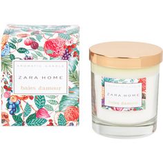 a candle that is next to a box with flowers on it and the label says zara home