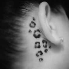 the back of a woman's neck with leopard print on it, behind her ear