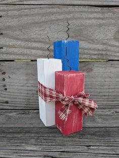 three wooden blocks tied with a bow on top of each other in front of wood planks