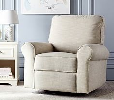 a living room with a chair, lamp and pictures on the wall in it's corner