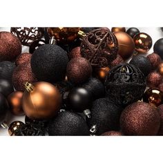 a pile of black and gold christmas ornaments