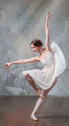 a young ballerina is posing for the camera