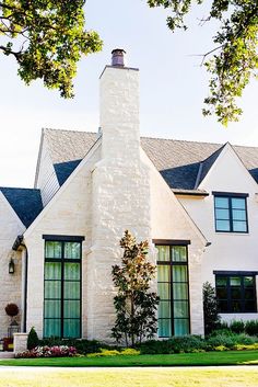 the front of a white brick house with black windows