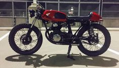 a red and black motorcycle parked in a parking lot