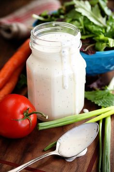 a jar of ranch dressing next to fresh vegetables