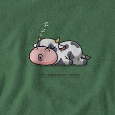 a cow laying down on top of a green shirt