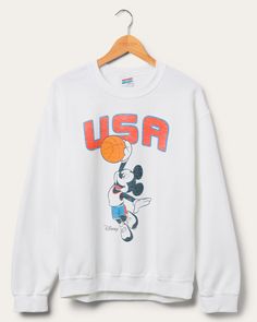 Elevate your street style with our USA Mickey Basketball Flea Market Fleece! Designed for basketball enthusiasts and Disney fans alike, this cozy fleece showcases a vibrant blend of American pride and Mickey Mouse magic. Stay warm while representing your love for the game and the iconic Disney character. Score yours now! Shop the rest of our Disney Collection HERE and Shop the rest of our Pop Culture Collection HERE. © Disney White Mickey Mouse Sweatshirt For Winter, Winter White Mickey Mouse Sweatshirt, Sporty Cotton Sweatshirt With Character Print, White Mickey Mouse Winter Sweatshirt, White Cotton Mickey Mouse Sweatshirt, Throwback Sweatshirt For Game Day, Throwback Fan Merchandise Sweatshirt For Sports Season, Sporty Hoodie With Character Print, Casual Cartoon Print Sweatshirt For Fans