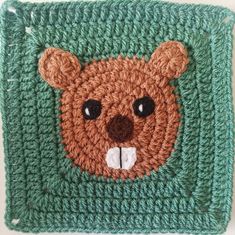 a crocheted square with a brown bear on it's face and eyes