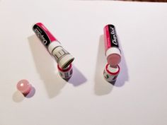 two tubes of lipstick sitting on top of a table