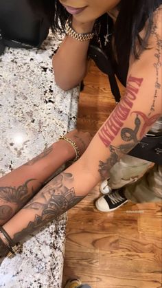 a woman with tattoos on her arm and leg