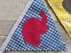 an elephant on a blue and white gingham cloth with a red felt piece in the middle