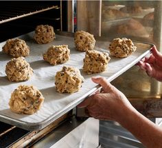 a person is taking cookies out of an oven