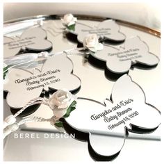 personalized wedding favors are arranged on a round tray with flowers and ribbons in the center