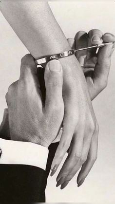 two hands holding each other with the help of a pair of scissors in front of them