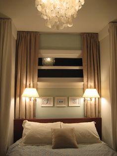 a bed with two lamps on either side of the headboard and one light above it