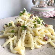 a white plate topped with pasta covered in sauce