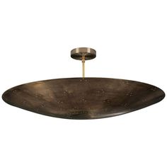 a large metal bowl hanging from the ceiling with a light fixture on it's side