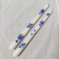 two toothbrushes with blue and white designs on them sitting on a towel next to each other