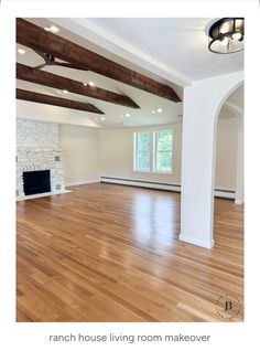 an empty living room with hard wood floors and exposed beams on the ceiling is shown