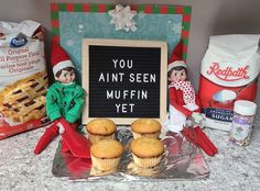 an elf is sitting next to some muffins