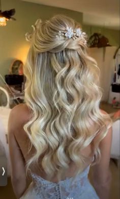 the back of a woman's head with long blonde hair and flowers in her hair