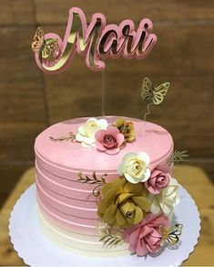 there is a pink cake with flowers on it and the word marr spelled in cursive letters