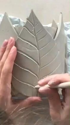 someone is making a vase out of clay and then it's being sculpted into a leaf