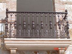 a balcony with wrought iron balconies and decorative railings on an old brick building