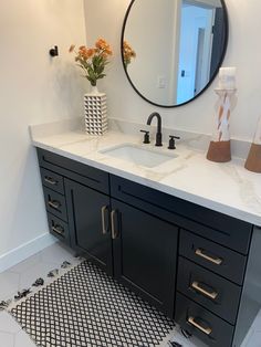 a bathroom with a sink, mirror and rug on the floor