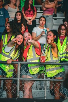 some people are wearing safety vests and one is holding a cell phone