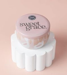 a pink and white container sitting on top of a white cake stand with the words sweet grace printed on it